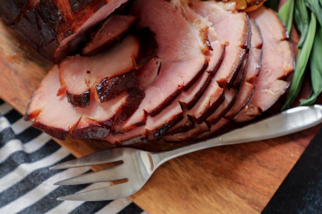 Low carb holiday ham sliced on a cutting board.