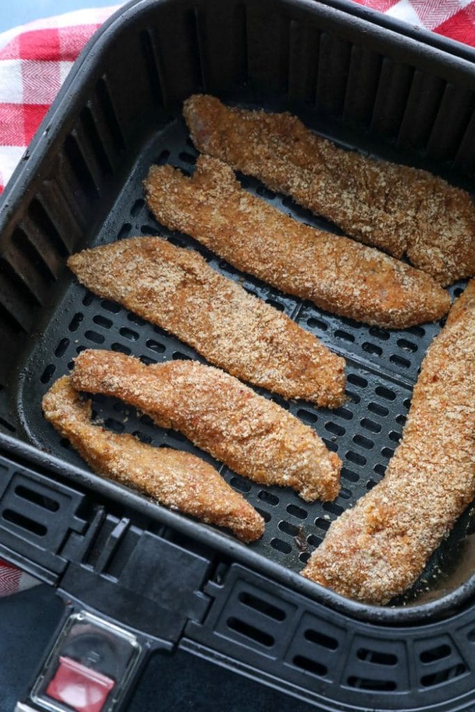 air fryer basket filled with cajun almond flour chicken tenders