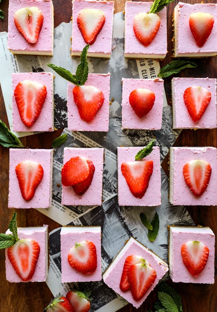 Easy Keto Strawberry Cheesecake Bars on a brown board.