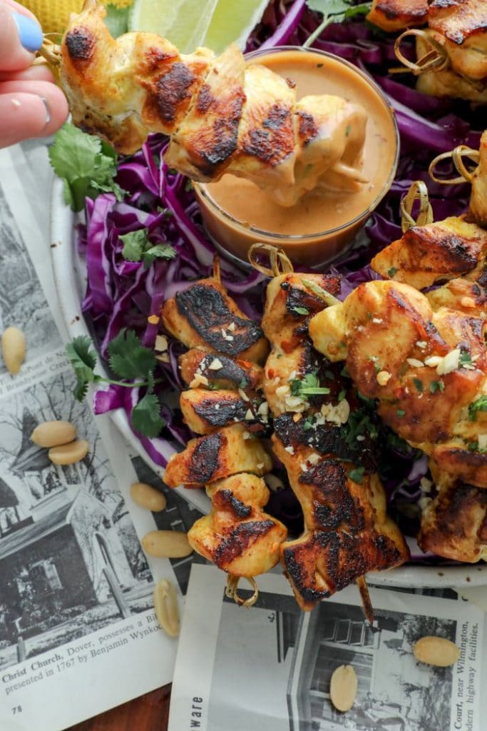 Thai Chicken Satay being dipped into the peanut sauce.