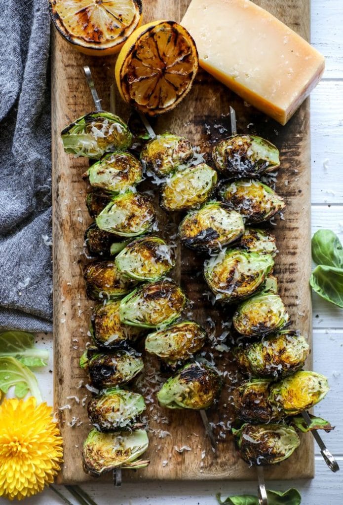 Grilled Lemon Pepper Parmesan Brussels Sprouts placed on a platter with parmesan over the top.