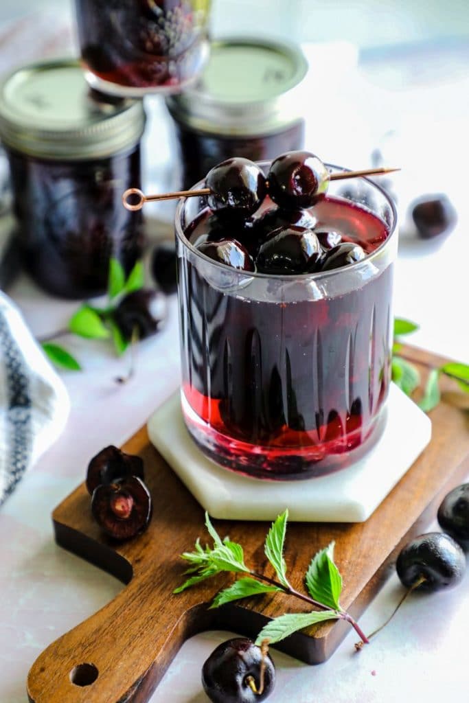 a glass filled with homemade maraschino cherries