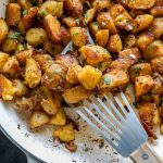 Crispy Garlic Herb Roasted Potatoes with a spatula