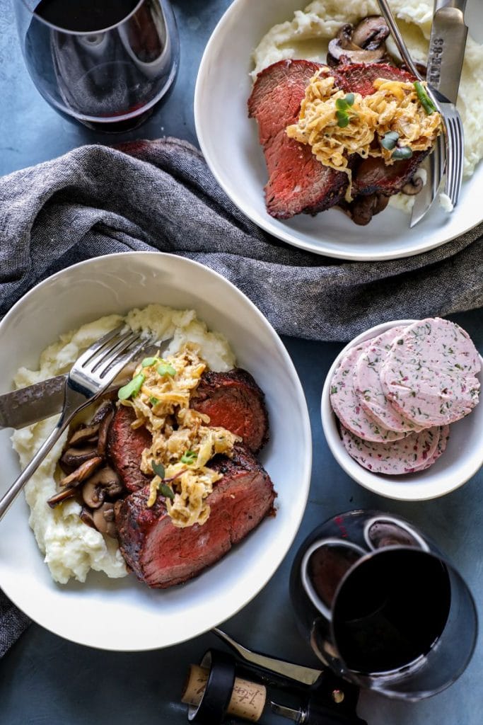 Smoked beef tenderloin plated with mashed potatoes and caramelized onions 