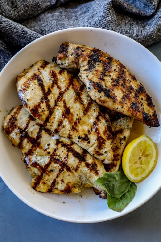 Grilled chicken resting in a bowl after cooking