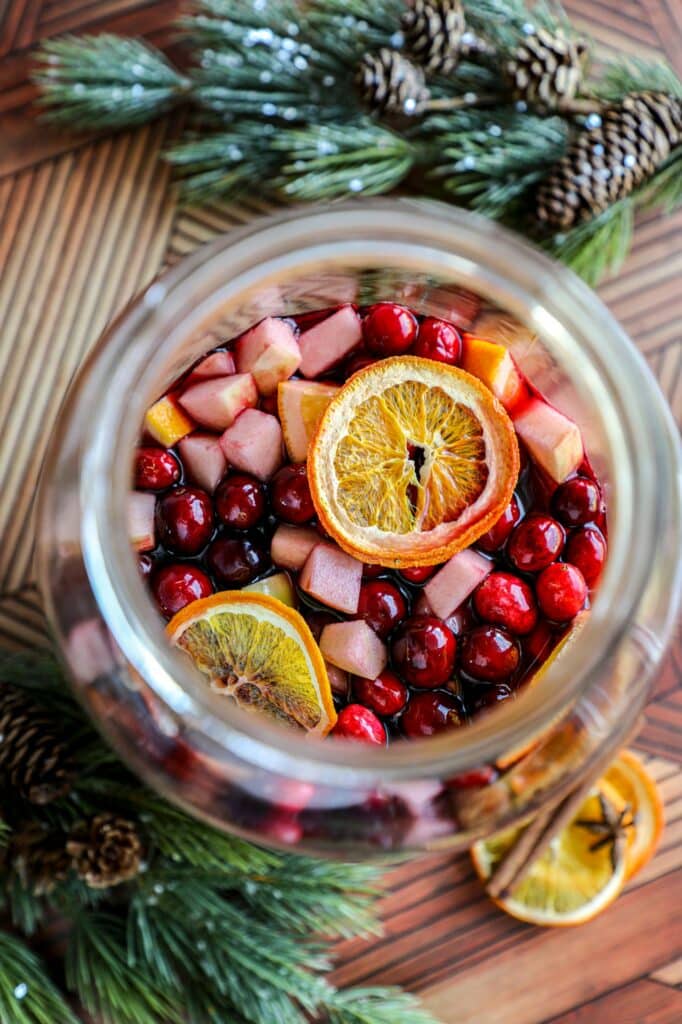 Top view of sangria in a large jar, with fruit sitting on top of the liquid.