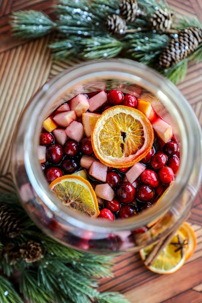 Top view of sangria in a large jar, with fruit sitting on top of the liquid. 