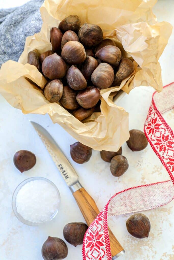 Fresh chestnuts and sea salt on a cutting board 