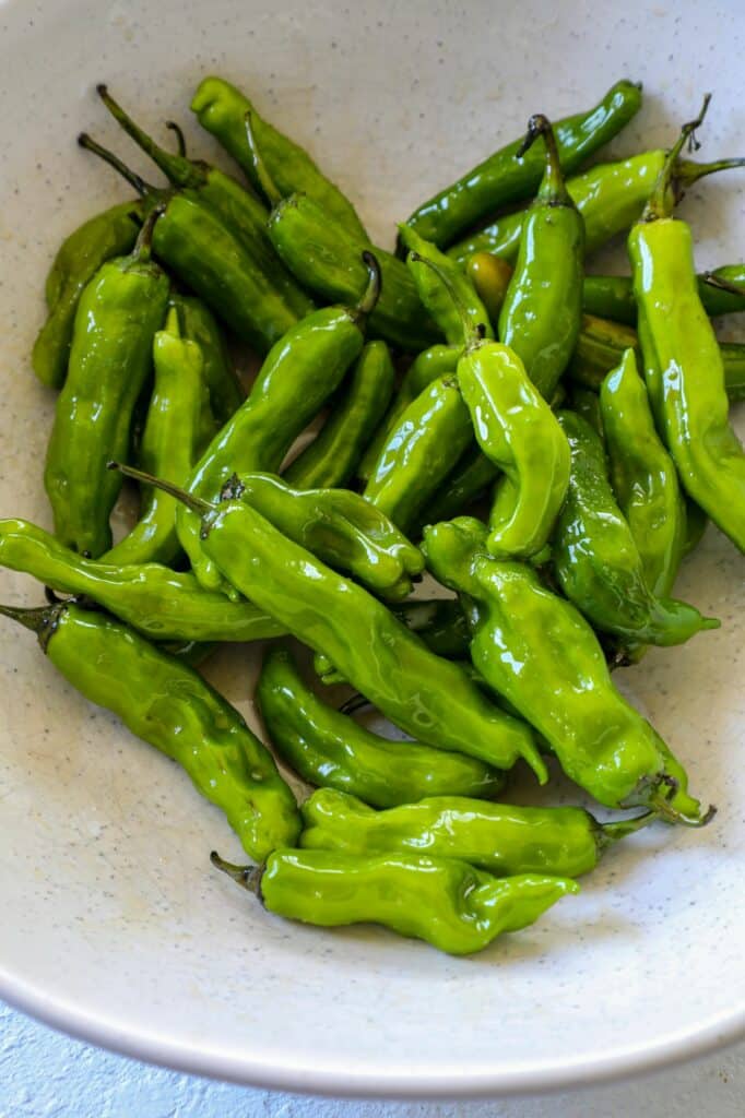 Raw shishito peppers in a bowl. 