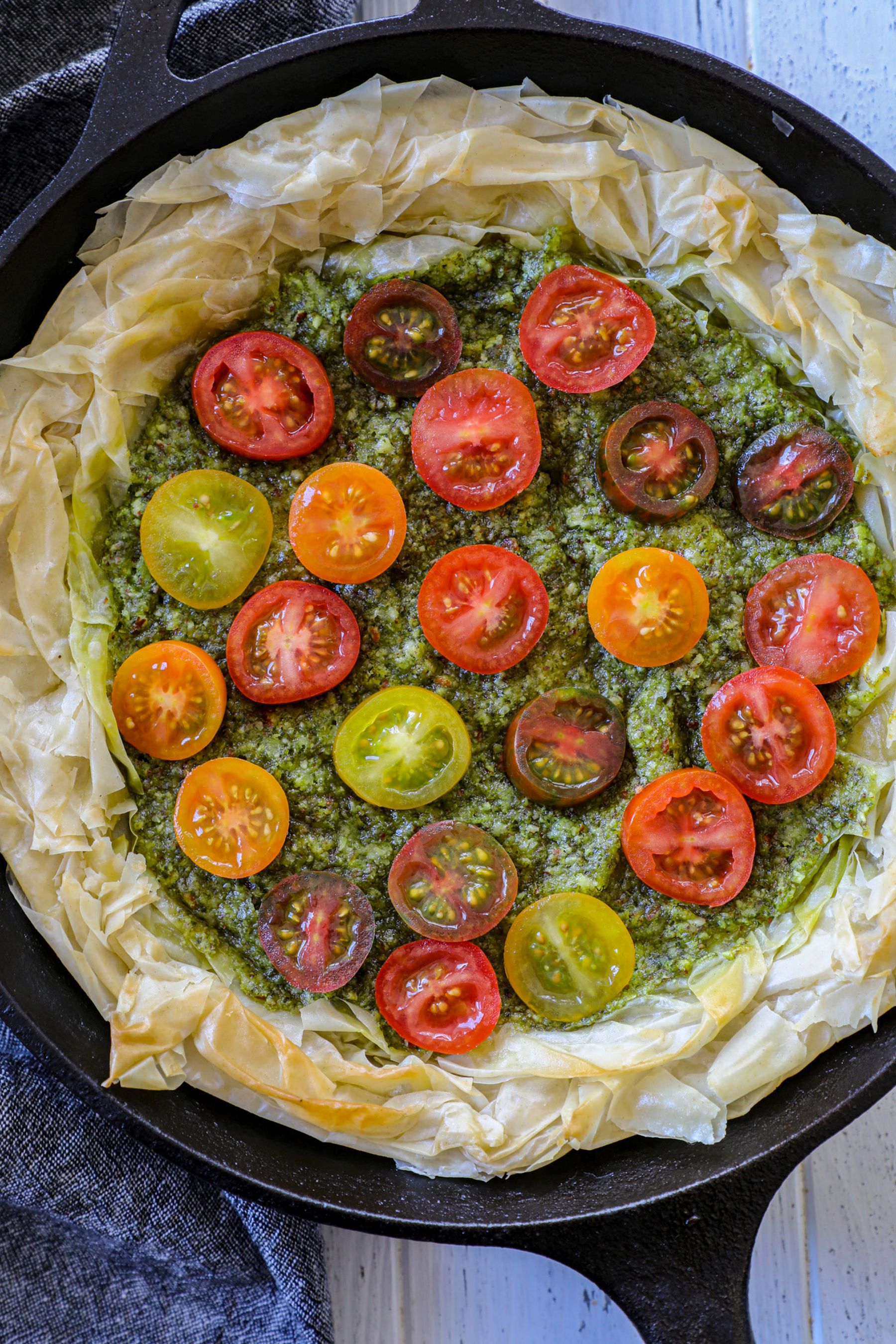 Tomatoes layered into the pesto phyllo tart base 