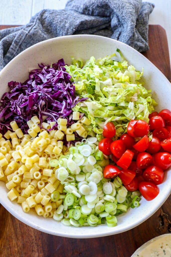 Assembling the chopped salad in a large mixing bowl.