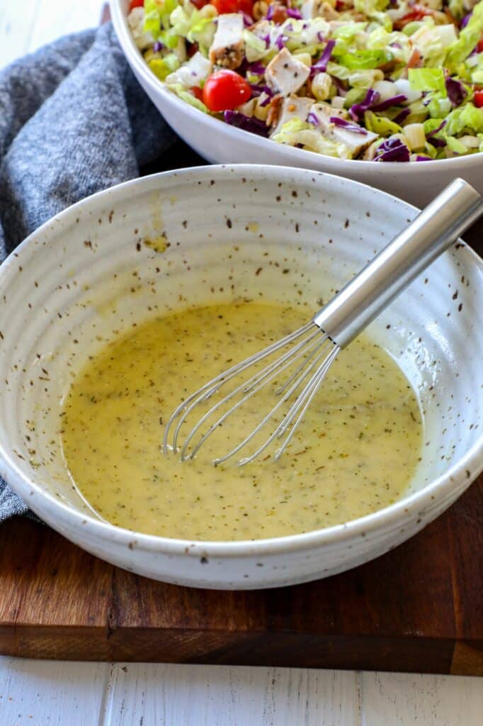 Portillos chopped salad dressing in a mixing bowl with a whisk. 