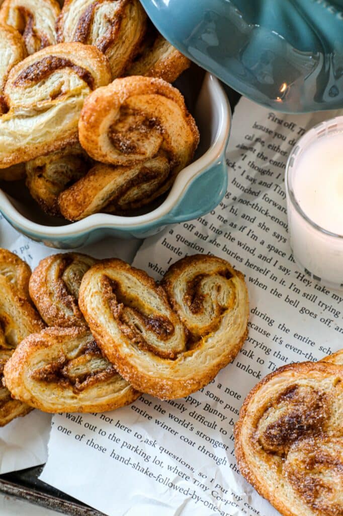Pumpkin Butter Puff Pastry Palmiers on newspaper with more on the side in a small dutch oven. 