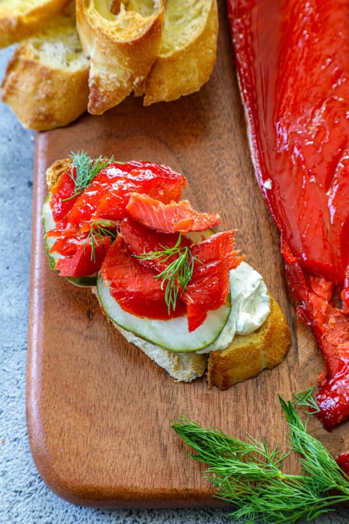 Hot smoked salmon served with cream cheese, cucumber and dill on a crostini 